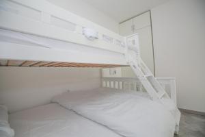 a bedroom with a white bunk bed with a ladder at Vila Varagic in Budva