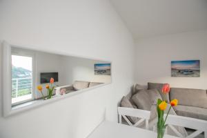 a white living room with a couch and a mirror at Vila Varagic in Budva