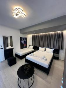 a hotel room with two beds and a table at Euphoria Apartments in Sarandë