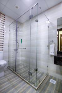 a glass shower in a bathroom with a toilet at Belle Tower Apartments in Manama