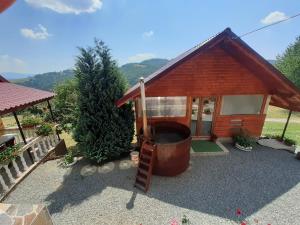 ein kleines Haus mit einer Leiter und einem großen Fass in der Unterkunft Cabana Robert in Arieşeni