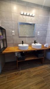a bathroom with two sinks and a mirror at La Voûte - Maison de charme in Saint-Clair