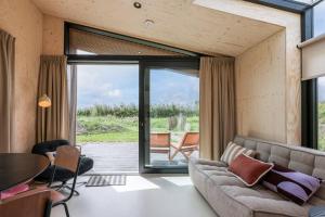 ヴェストカペレにあるHello Zeeland - Tiny House Zeeuwse Liefde 15のソファと大きな窓のあるリビングルーム