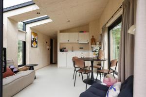 ヴェストカペレにあるHello Zeeland - Tiny House Zeeuwse Liefde 15のリビングルーム、キッチン(テーブル、椅子付)
