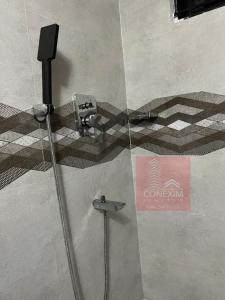 a glass shower door with a faucet in a bathroom at Fully Furnished One Bed Room Apartment with Kitchen A007 in Dhaka