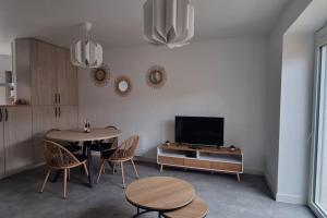 a living room with a table and chairs and a tv at Maison DEOLS centre 41 pour 1 ou 2 personnes in Déols