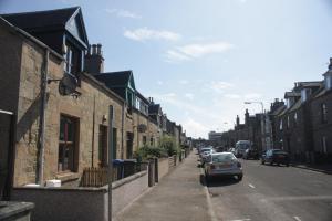 a car parked on the side of a street with buildings at Innes Street Apartments in Inverness