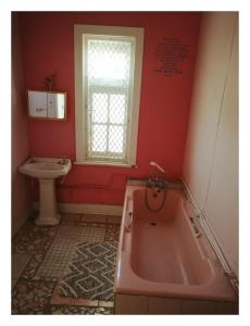 Un baño con una bañera rosa y un lavabo. en Swartkops Cann-a-bee Air B&B, en Gqeberha 18 fotos más