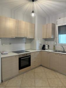 eine Küche mit weißen Schränken und einem schwarzen Backofen in der Unterkunft VALENTINA Luxury apartment in Kavala