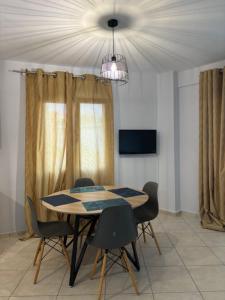 einen Esstisch mit Stühlen und einem Kronleuchter in der Unterkunft VALENTINA Luxury apartment in Kavala