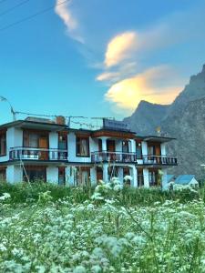 a building on a hill with mountains in the background at The Shangbar in Jispa