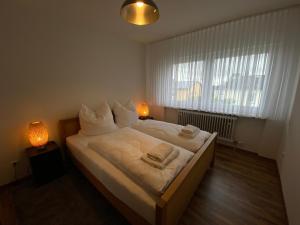 a bedroom with a large bed with two towels on it at Gästehaus Eschborn, Frankfurt in Eschborn