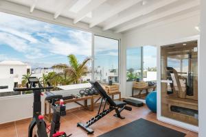 ein Apartment-Fitnessstudio mit großem Fenster und Trainingsgeräten in der Unterkunft Villa María in Playa Blanca