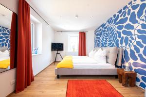 Un dormitorio con una cama con una pared azul y blanca en Bunter Hund Apartments - Zentrales Apartment, Parkplatz, Wintergarten, Kinderzimmer, en Rothenburg ob der Tauber