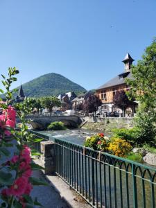 un pont sur une rivière dans une ville fleurie dans l'établissement Studio cosy classé 3 étoiles dans cœur historique, à Arreau