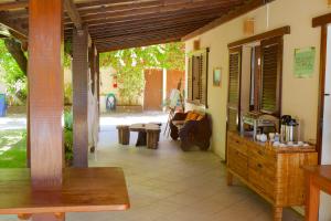 a porch of a house with a bench and a table at Pousada Stella Tropical in Salvador