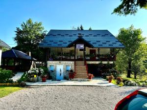 a house with a blue door with a solar roof at Guest House Family Varda Plitvice Lakes in Plitvička Jezera