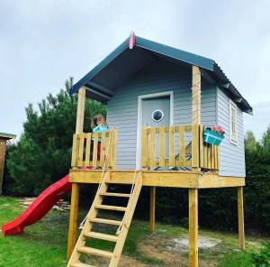 a girl in a play house with a slide at Lawendowe Zacisze 2 in Odargowo