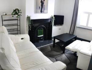 a living room with a white couch and a fireplace at Charming home in Beverley in Beverley