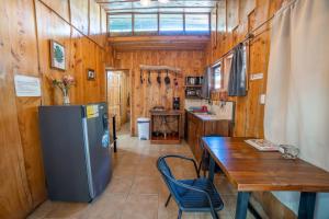 a small kitchen with a table and a refrigerator at Villa Tabacon in Monteverde Costa Rica +10 photos