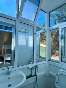a bathroom with four windows and a sink at Mimi's Apartments in Vlorë