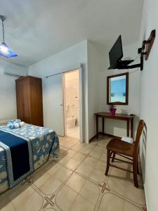 a bedroom with a bed and a table and a television at Hotel Giglio in Lampedusa