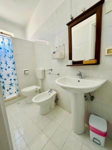 a white bathroom with a sink and a toilet at Hotel Giglio in Lampedusa +37 photos