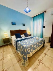 a bedroom with a large bed with blue walls at Hotel Giglio in Lampedusa