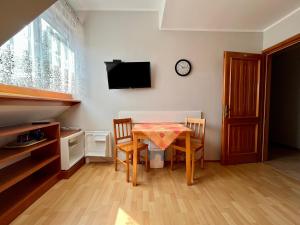 a dining room with a table and chairs and a tv at Pokoje gościnne Pod bocianami in Stegna +2 photos