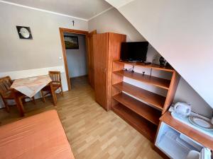 a living room with a table and a television at Pokoje gościnne Pod bocianami in Stegna