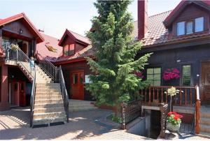 a house with a staircase and a tree in front of it at Pokoje gościnne Pod bocianami in Stegna