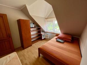 a small room with a bed in a attic at Pokoje gościnne Pod bocianami in Stegna