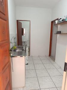 a bathroom with a sink and a mirror at Casarão Pertinho da Praia in Bertioga