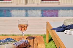 a glass of wine sitting on a table at Résidence Les volets rouges - Duplex de standing avec piscine in Oletta