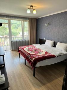 a bedroom with a bed with a red blanket on it at Roza Guesthouse in Stepantsminda