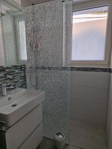 a bathroom with a sink and a shower with a window at Tolle zentrale Wohnung in Engelberg