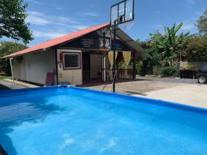 a swimming pool in front of a building with a basketball hoop at Casa Noe - Noe House in Macas