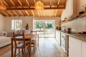 a kitchen and dining room with a wooden table and chairs at OAK Monte Alentejano - 2 casas T2 alugadas sempre em simultâneo toda a propriedade é exclusiva a uma só reserva in Santiago do Cacém