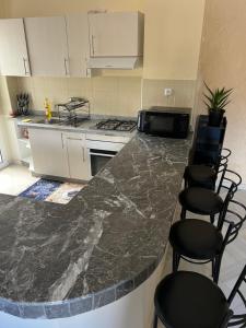 a kitchen with a marble counter top and chairs at Tangier new city Apartment in Tangier