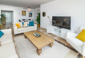 a living room with white furniture and a flat screen tv at Luxury 3 bed Duplex Penthouse, 3 mins walk to the beach in Estepona +27 photos