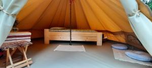 a tent with a bed in the middle of it at Secret Garden Camping in Bontida