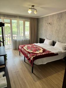 a bedroom with a bed with a red blanket on it at Roza Guesthouse in Stepantsminda