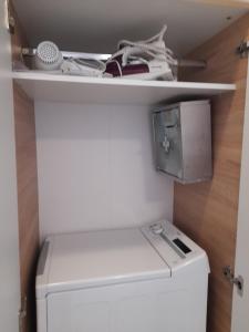 a laundry room with a washer and dryer on a shelf at Heraklion Centre Experiene in Heraklio