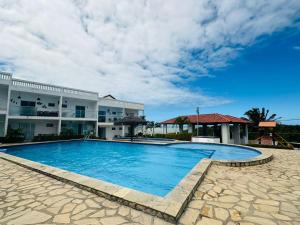 a large swimming pool in front of a building at Apto em Jacumã in Conde