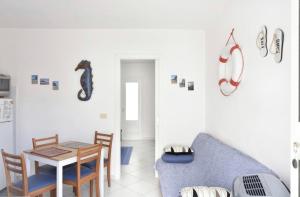 a living room with a table and a blue couch at Casa M&M in Cala Gonone