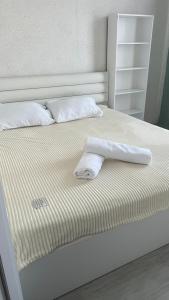 a white bed with two towels on top of it at Metro city apartment Angisa 72 in Batumi +9 photos