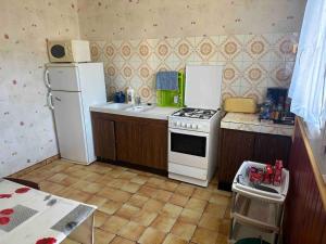 a kitchen with a white stove and a refrigerator at Vaste villa au coeur de la pinède in Les Mathes +9 photos