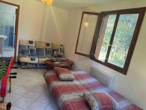a bedroom with two beds and a table and windows at Vaste villa au coeur de la pinède in Les Mathes