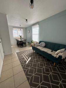 a living room with a green couch and a table at Hotel Boutique Paqari casas completamente amobladas in Vallenar