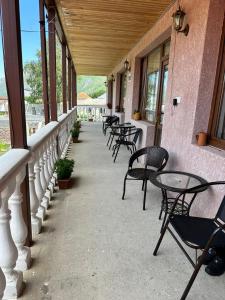 a row of tables and chairs on a porch at Roza Guesthouse in Stepantsminda